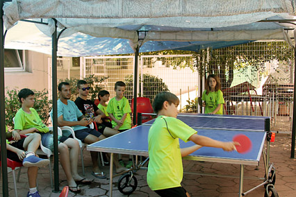 Jugando al ping pong a la sombra en el Campus de Verano de la EDM San Blas. 